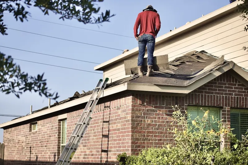 Professional roofer working on a residential roof in Gilford